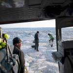 In this Aug. 16 photo, New York University air and ocean scientist David Holland (left) and field safety officer Brian Rougeux (right) are helped by pilot Martin Norregaard as they carry antennas out of a helicopter to be installed at the Helheim glacier, in Greenland. Holland and his NYU team are tracking whats happening in Greenland from both above and below. (AP Photo/Felipe Dana)