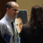 A large photo of slain federal prosecutor Thomas C. Wales is seen between his son Tom Wales (left) and daughter Amy Wales as they talk after a ceremony in a courtroom at the Federal Courthouse in Seattle in October 2006. (AP Photo/John Froschauer, file)