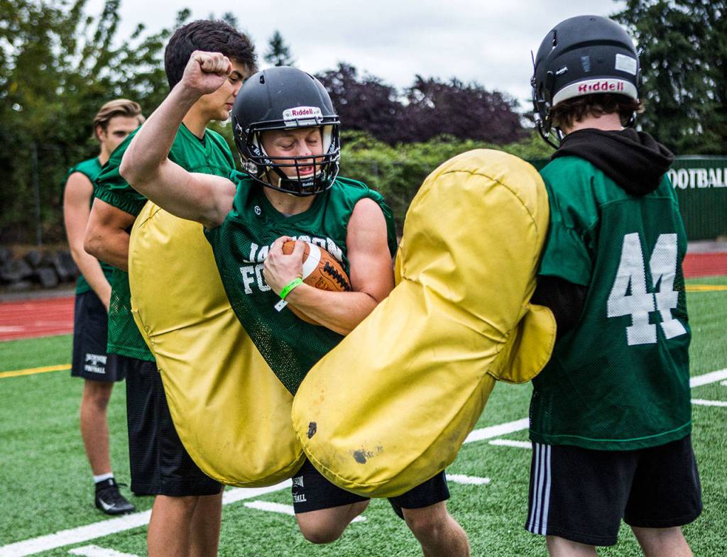 Jacksons Josh Aho pushes through pads during a drill. (Olivia Vanni / The Herald)