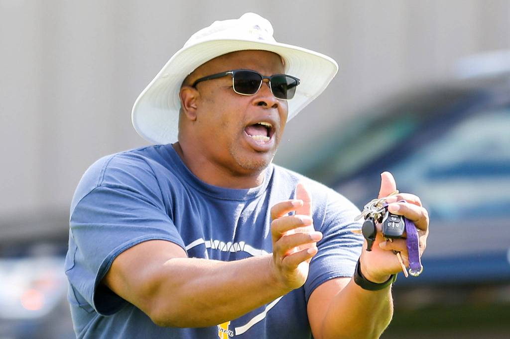 Mariner coach Mark Stewart demonstrates proper technique during practice on Aug. 22, 2019, at Mariner High School in Everett. (Kevin Clark / The Herald)