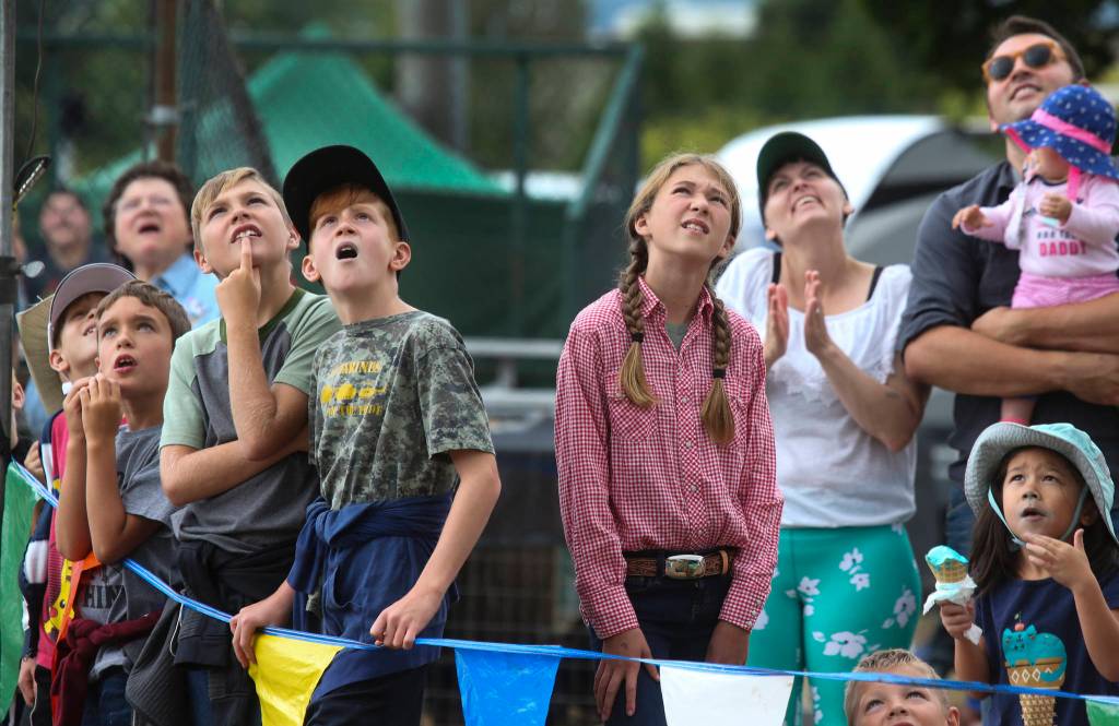 Kids watch as loggers climb 60 foot poles during the International Lumberjack Show on opening day of the Evergreen State Fair on Thursday, Aug. 22, 2019 in Monroe, Wash. The cabin is the first building to be placed on the Snohomish County Register of Historic Places. (Andy Bronson / The Herald)