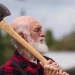 Alvie Marcellus takes look at his target before throwing an axe during the International Lumberjack Show on opening day of the Evergreen State Fair on Thursday, Aug. 22, 2019 in Monroe, Wash. The cabin is the first building to be placed on the Snohomish County Register of Historic Places. (Andy Bronson / The Herald)