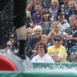 Audience members watch as two lumberjack compete in a log rolling event during the International Lumberjack Show on opening day of the Evergreen State Fair on Thursday, Aug. 22, 2019 in Monroe, Wash. The cabin is the first building to be placed on the Snohomish County Register of Historic Places. (Andy Bronson / The Herald)