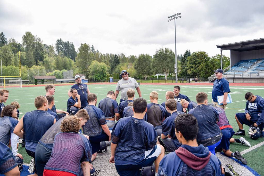 The Sultan High School football team gathers at the end of practice on Aug. 23, 2019, at Sultan High School. (Katie Webber / The Herald)