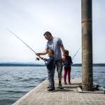Gino Sanita (center) teaches his son Carlo, 5, and daughter Virgina, 7, how to fish off of the boat launch dock at Camano Island State Park on June 9. (Olivia Vanni / The Herald)
