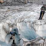 Scientist Mauri Pelto balances on the walls of an ice chute to take footage of a water current on <a href="https://www.heraldnet.com/news/chronicling-the-last-years-of-a-dying-north-cascades-glacier/" target="_blank">Columbia Glacier</a>. (Zachariah Bryan / The Herald)