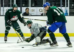 Jack Lambert (center) scrambles for the puck with Nate Goodbrandson (left) and Blake Setter (right) during the Slivertips annual Green vs. Grey scrimmage Sunday at Everetts Angel of the Winds Arena. (Olivia Vanni / The Herald)