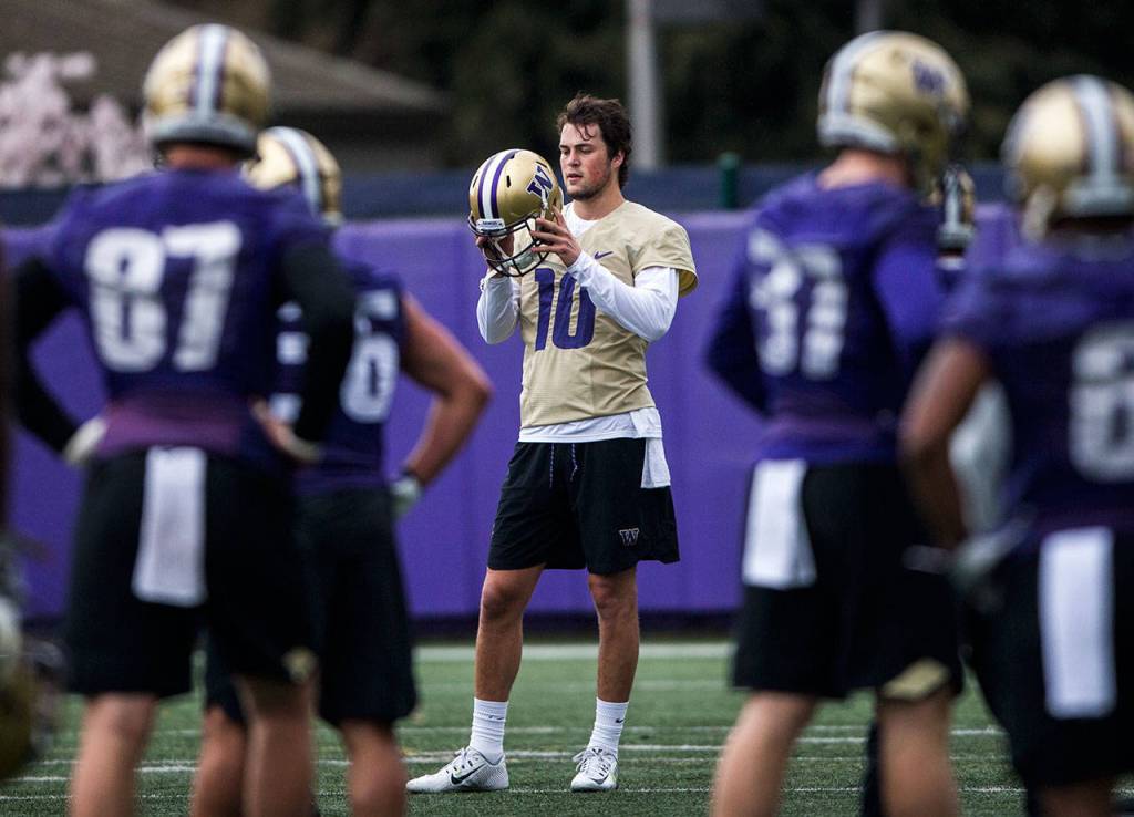 Jacob Eason takes his helmet off between drills during football practice at the University of Washington on April 3 in Seattle. (Olivia Vanni / Herald file)