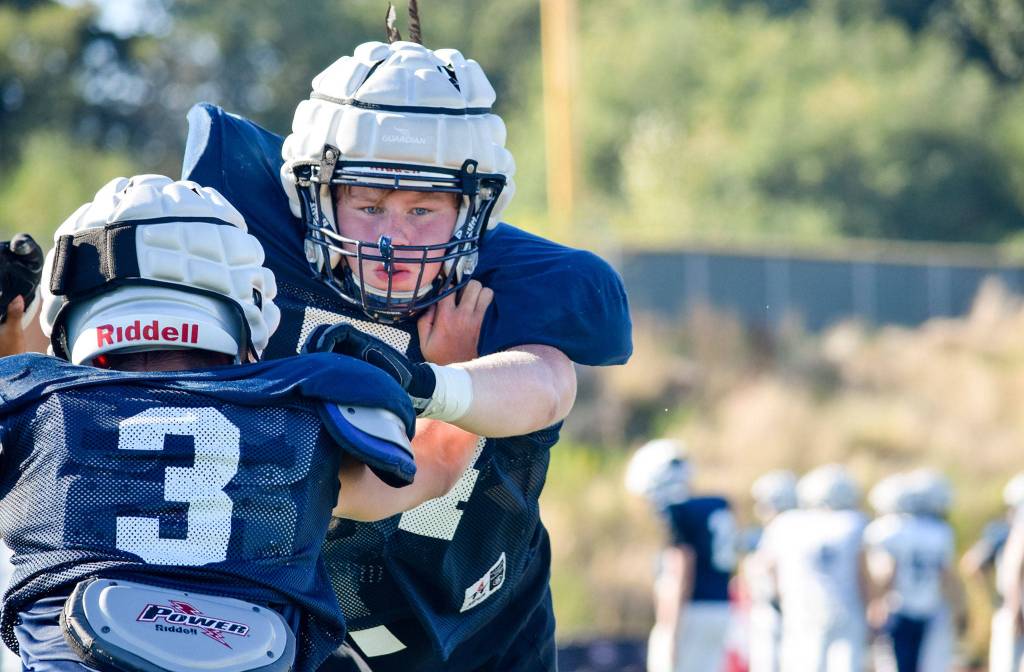 Senior Jacob Anderson pushes past the offense while practing defensive plays on Aug. 27, 2019, at Glacier Peak High School in Snohomish. (Katie Webber / The Herald)