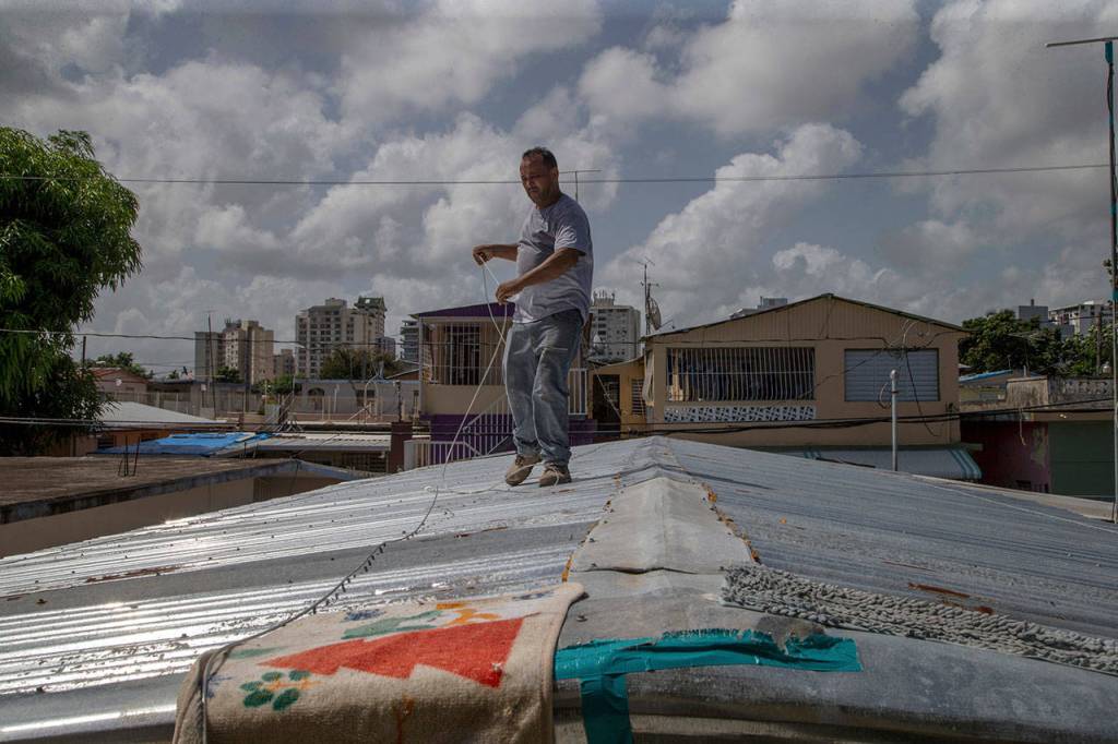 Jorge Ortiz works to tie down his roof Tuesday as he prepares for the arrival of Tropical Storm Dorian, in the Martín Peña neighborhood of San Juan, Puerto Rico. The 50-year-old construction worker was taking no chances as Dorian approached Puerto Rico on Tuesday and threatened to brush past the islands southwest coast at near-hurricane strength. (AP Photo/Gianfranco Gaglione)