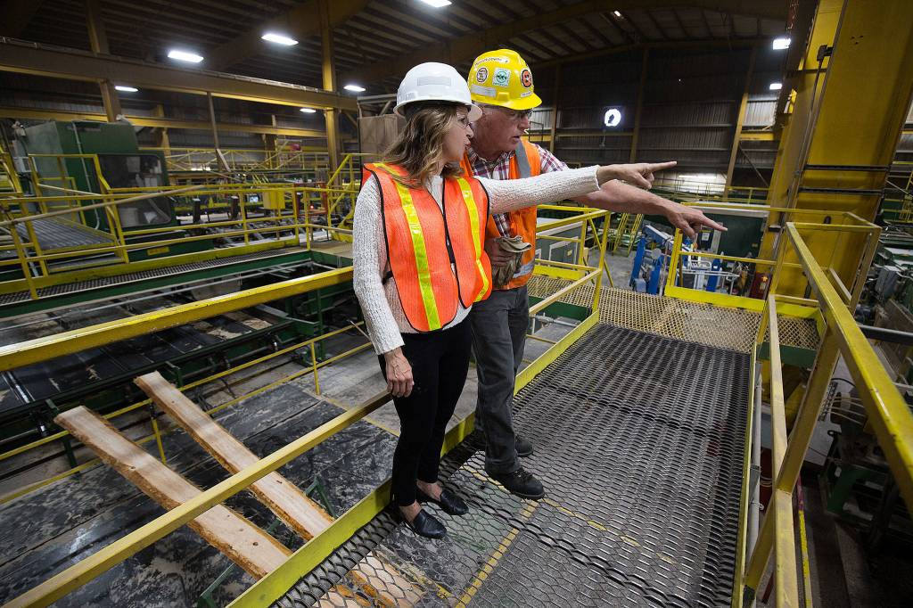 Commissioner of Public Lands Hilary Franz and Hampton Mill manager Tim Johnson talk over the noise of the mill during a tour Thursday in Darrington. (Andy Bronson / The Herald)