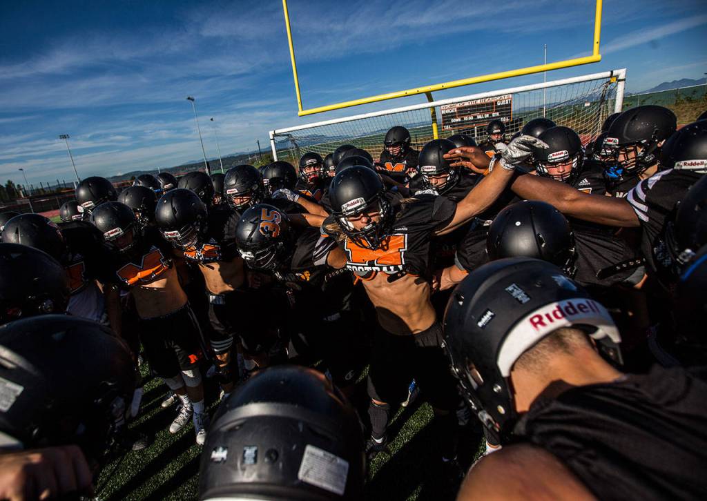 The Bearcats gather in a huddle before the start of practice. (Olivia Vanni / The Herald)
