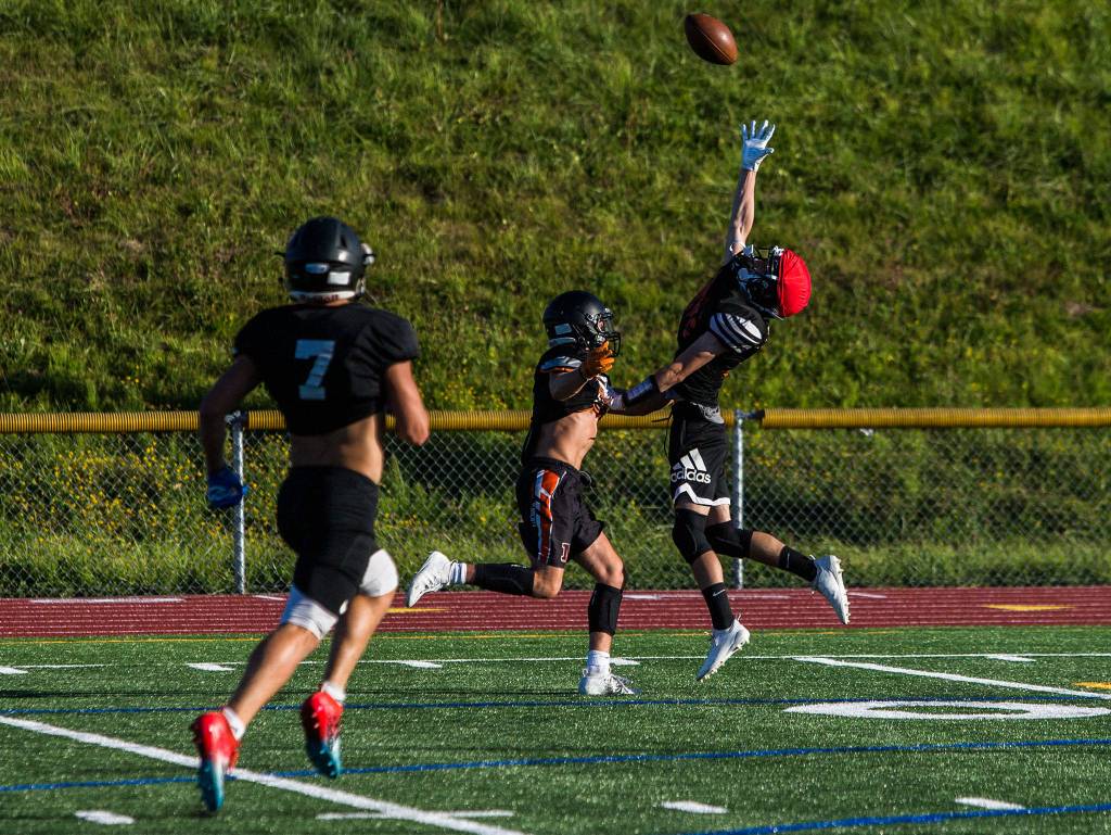 A player jumps for a pass during football practice at Monroe High School on Wednesday, Aug. 28, 2019 in Monroe, Wash. (Olivia Vanni / The Herald)