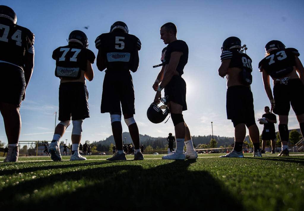Players wait to be called into a drill during football practice at Monroe High School on Wednesday, Aug. 28, 2019 in Monroe, Wash. (Olivia Vanni / The Herald)