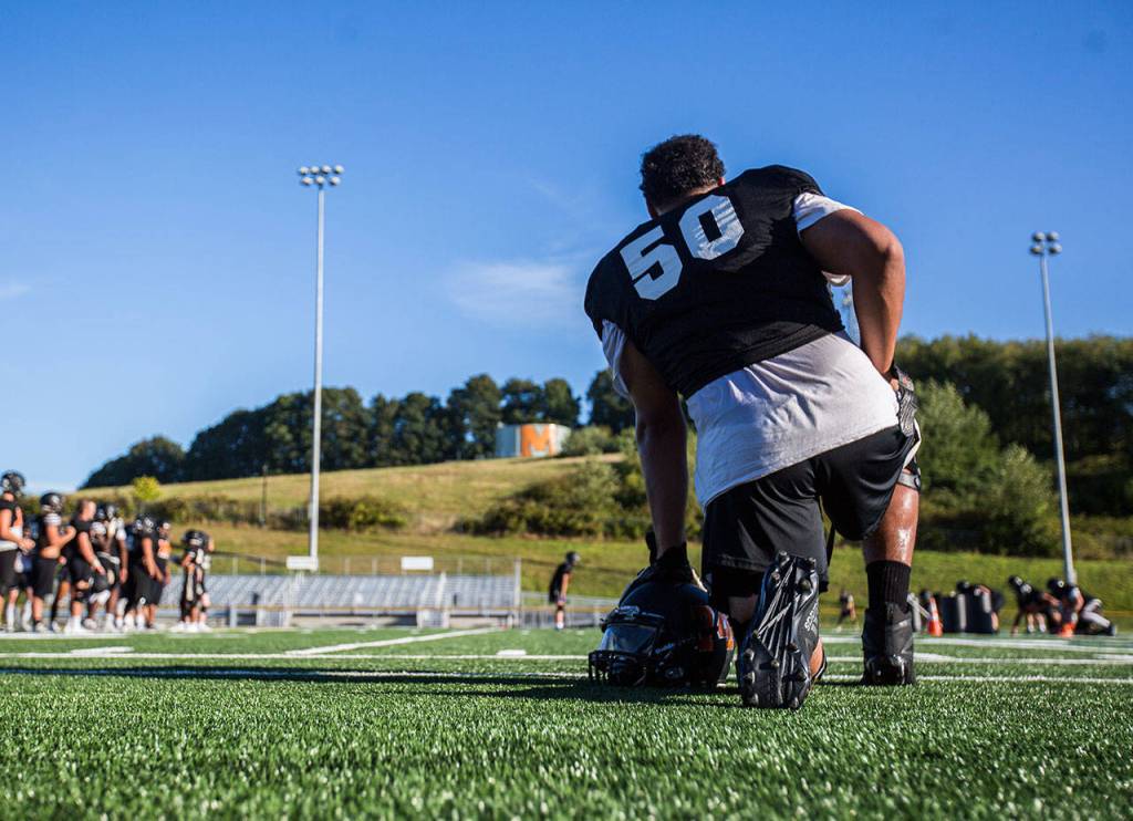 Casey Lynch takes a knee during football practice at Monroe High School on Wednesday, Aug. 28, 2019 in Monroe, Wash. (Olivia Vanni / The Herald)