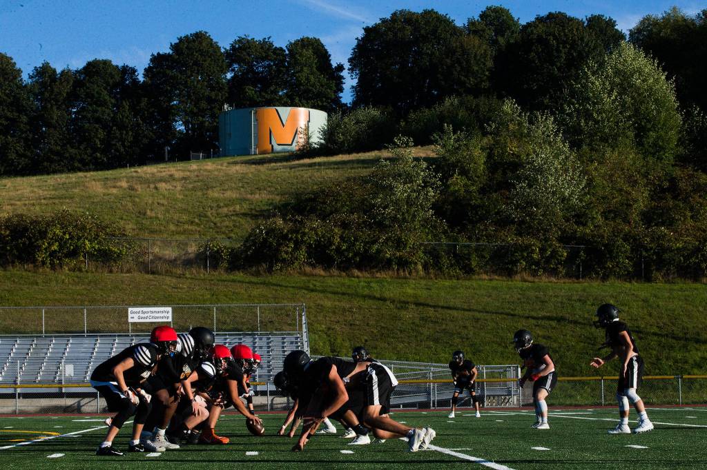 Players lineup to run through plays during football practice at Monroe High School on Wednesday, Aug. 28, 2019 in Monroe, Wash. (Olivia Vanni / The Herald)