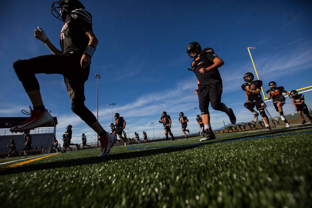 Players warm up during football practice at Monroe High School on Wednesday, Aug. 28, 2019 in Monroe, Wash. (Olivia Vanni / The Herald)