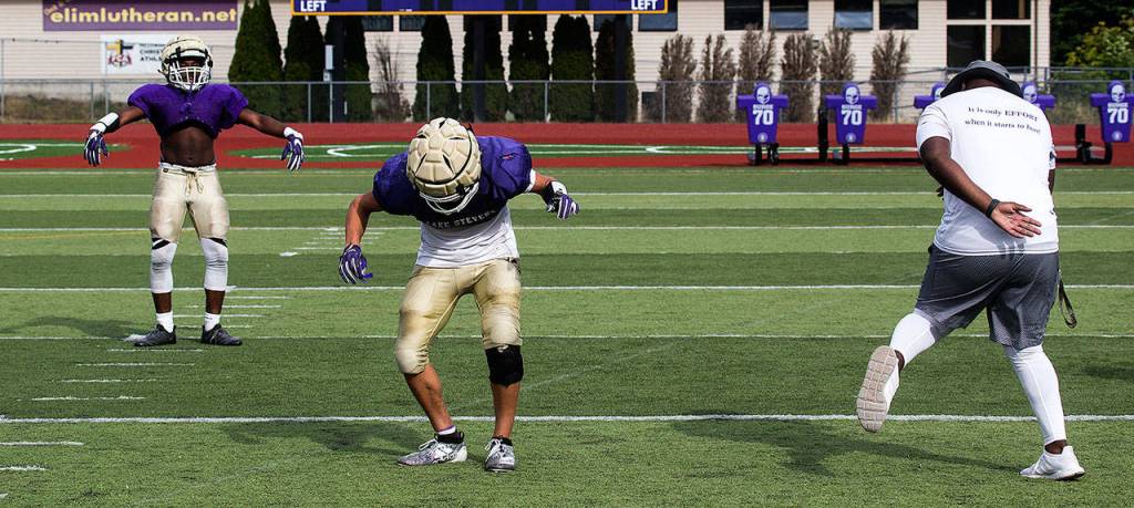 With music blaring on the stadium speakers, a Lake Stevens coach and players dance between plays during a recent practice. (Andy Bronson / The Herald)