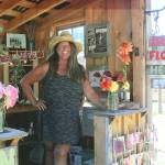 Tamara Knapp stands inside her familys Anderson Farm dahlia shed on Al Anderson Road. The stand is open until dusk every day until the hundreds of seasonal dahlias run out. (Wendy Leigh /South Whidbey Record)