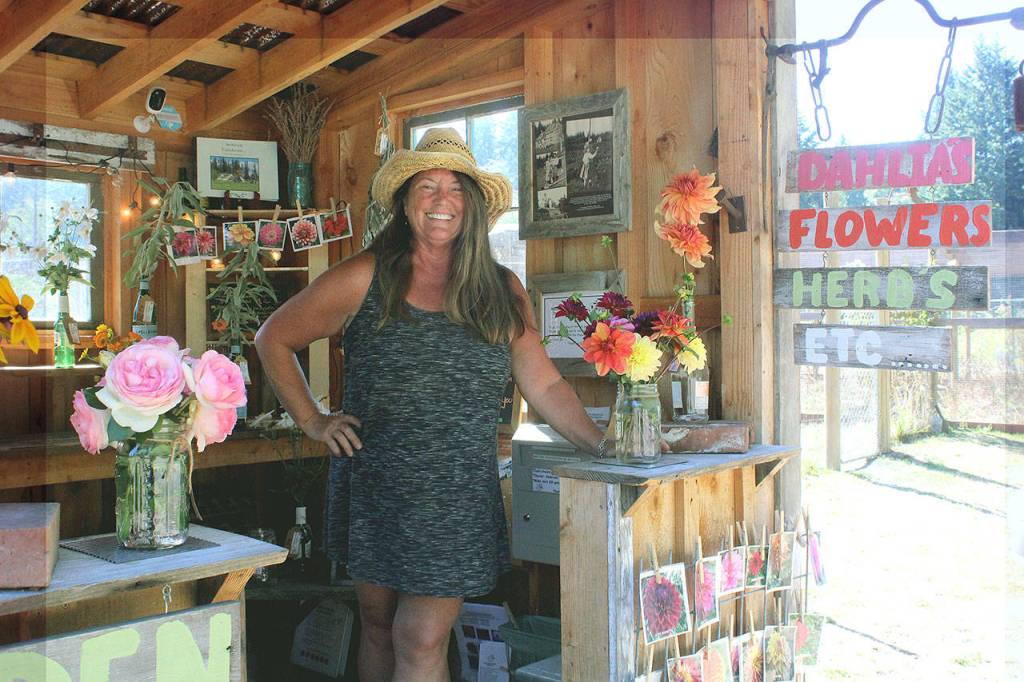 Tamara Knapp stands inside her familys Anderson Farm dahlia shed on Al Anderson Road. The stand is open until dusk every day until the hundreds of seasonal dahlias run out. (Wendy Leigh /South Whidbey Record)