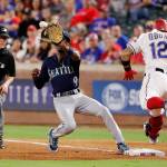 First base umpire Jerry Meals (left) watches as the Mariners Dee Gordon (9) reaches out for the throw to first for the out on a bunt attempt by the Rangers Rougned Odor (12) in the seventh inning of a game on Aug. 31, 2019, in Arlington, Texas. (AP Photo/Tony Gutierrez)