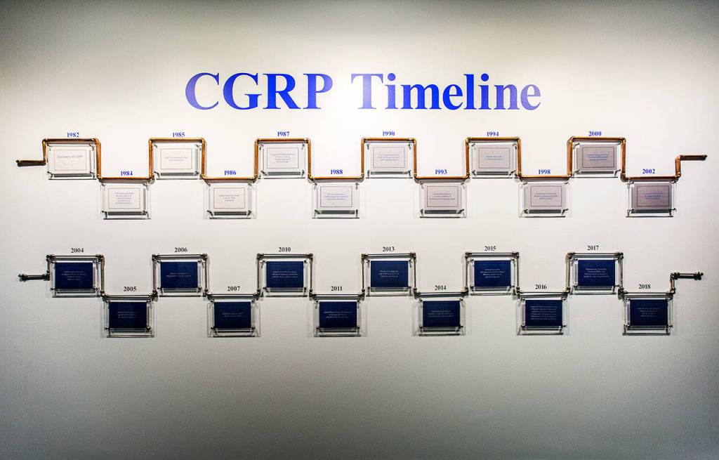 A timeline of the development of the Alder Biopharmaceuticals drug Eptinezumab is displayed in a hallway at the company labs in Bothell. (Olivia Vanni / The Herald)