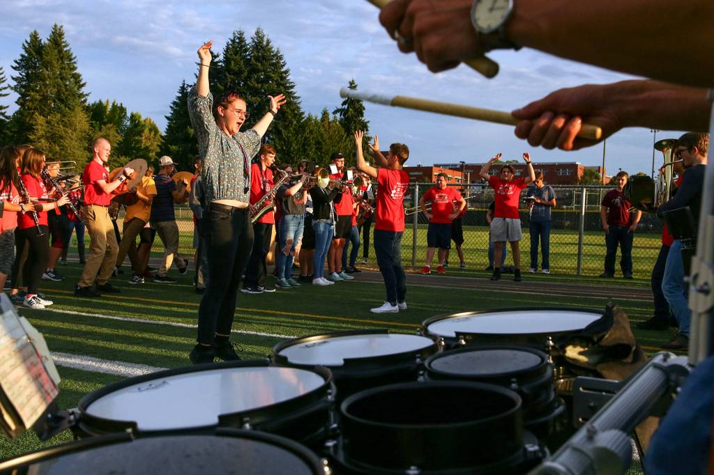 Rebecca Benedict leads her section of the band Thursday evening at Snohomish High, in preparation for the first football game of the season. (Kevin Clark / The Herald)