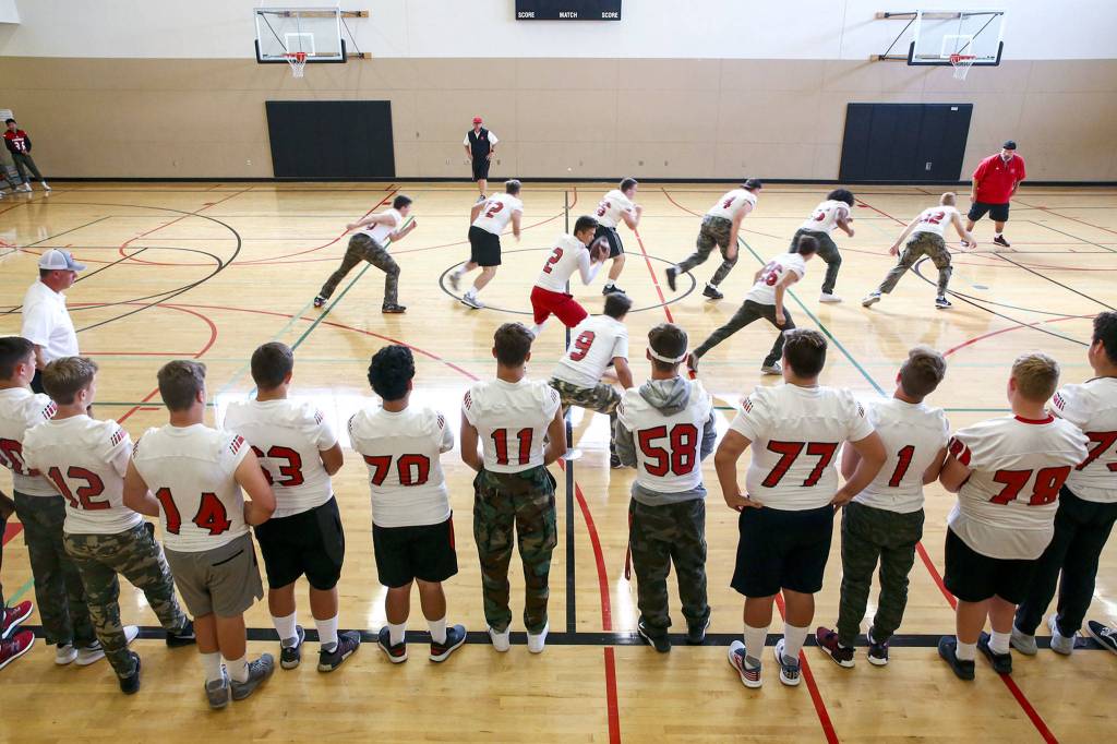 The Panthers walk through plays in the auxiliary gym at Snohomish High before the Aug. 30 jamboree at Lake Stevens High School. (Kevin Clark / The Herald)