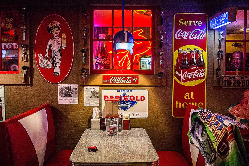 Antique signs hang next to a makeshift diner booth set up in one of the buildings at NardoLand. (Olivia Vanni / The Herald)