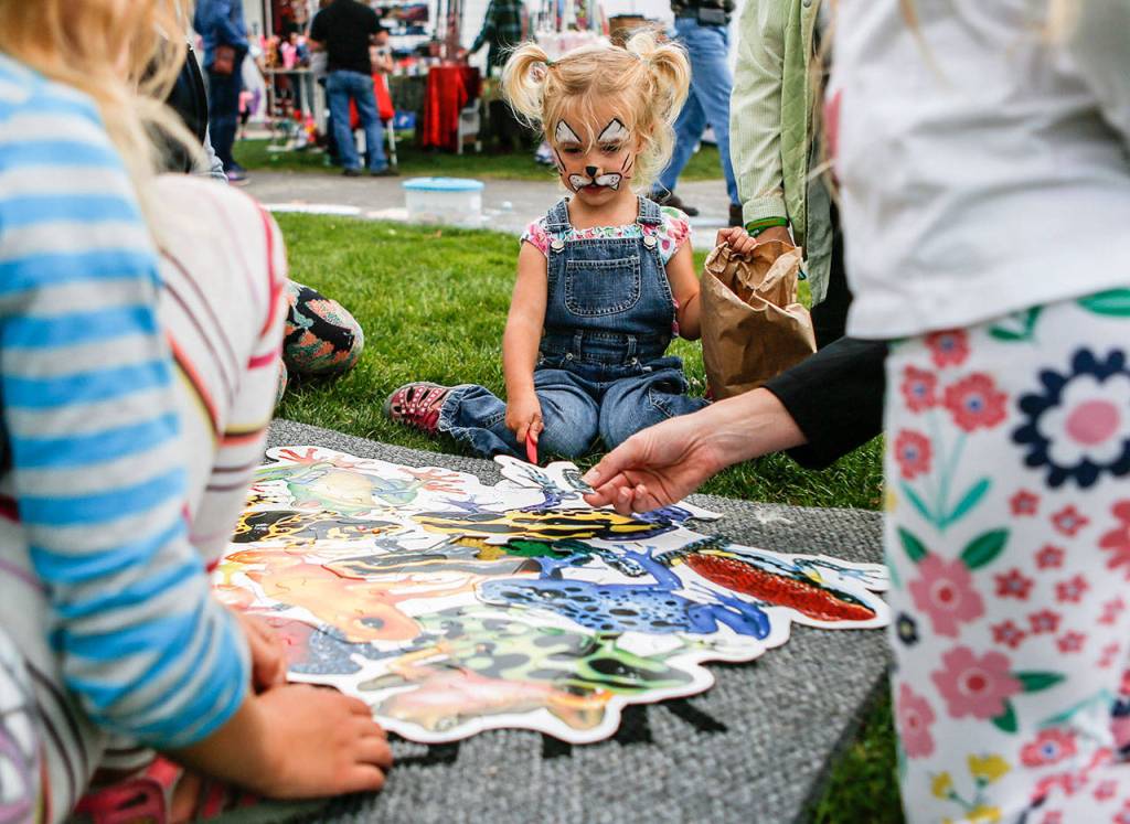 Amia Duckett, then 3, works on a kids puzzle during the Mukilteo Lighthouse Festival in 2018. This years festival is Sept. 6-8 at Mukilteo Lighthouse Park. (Olivia Vanni / The Herald)