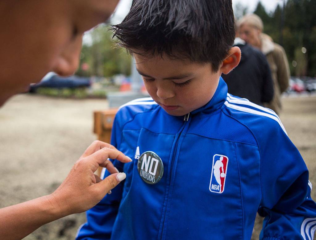 Gavin Gunthers mother puts a no uniforms pin on his jacket before he heads into school at Tambark Creek Elementary School on Wednesday. (Olivia Vanni / The Herald)