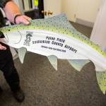 Andrew Rardin opens a package that contains Paine Fields Salmon Safe certification placard on Sept. 5 in Everett. (Olivia Vanni / The Herald)