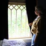 Susan Mausshardt looks out one of her homes many original windows, likely dating from when it was built in 1909. (Kevin Clark / The Herald)