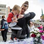 Natalie Scott (right) holds her son Ame, 3, while she lights a candle during Snohomish Overdose Preventions A Night to Remember on Thursday in Everett. (Olivia Vanni / The Herald)