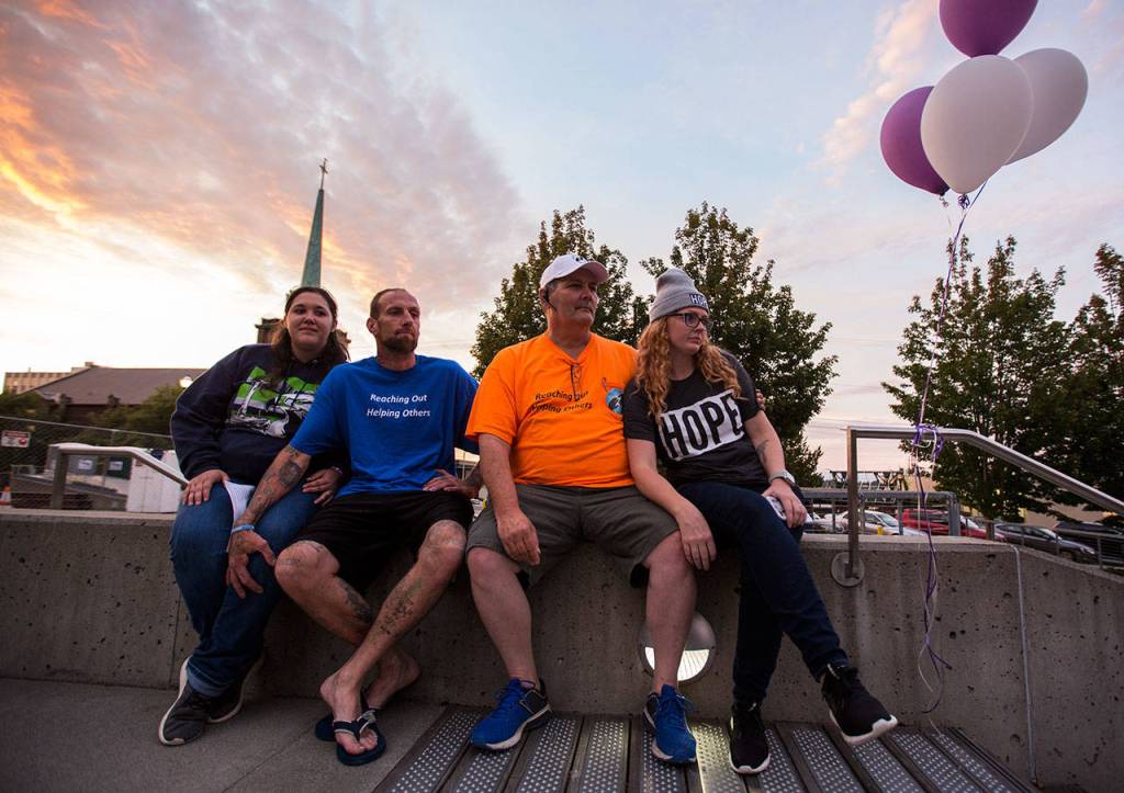 Breanne Miller (left), Troy Neilsen, Robert Smiley and Lindsey Arrington (right) listen to speakers during Snohomish Overdose Preventions A Night to Remember on Thursday in Everett. (Olivia Vanni / The Herald)