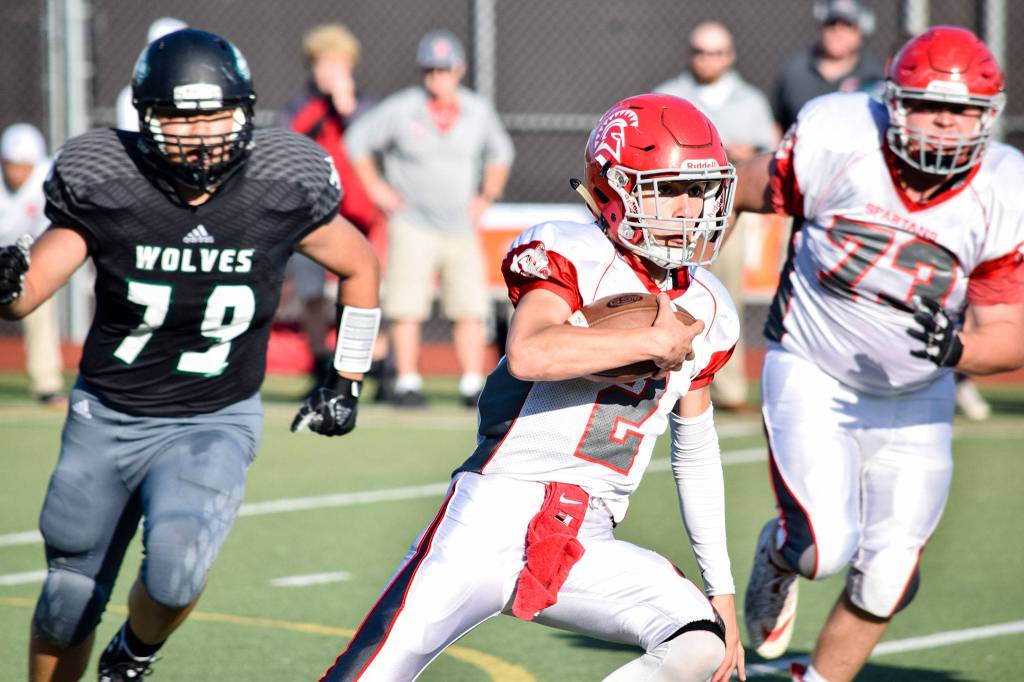 Senior quarterback Chase Norton runs with the ball against Jackson on Friday at Everett Memorial Stadium. (Katie Webber / The Herald)