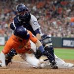The Astros Alex Bregman (bottom) scores as Mariners catcher Austin Nola loses the ball during the fifth inning of a game Sept. 6, 2019, in Houston. (AP Photo/David J. Phillip)