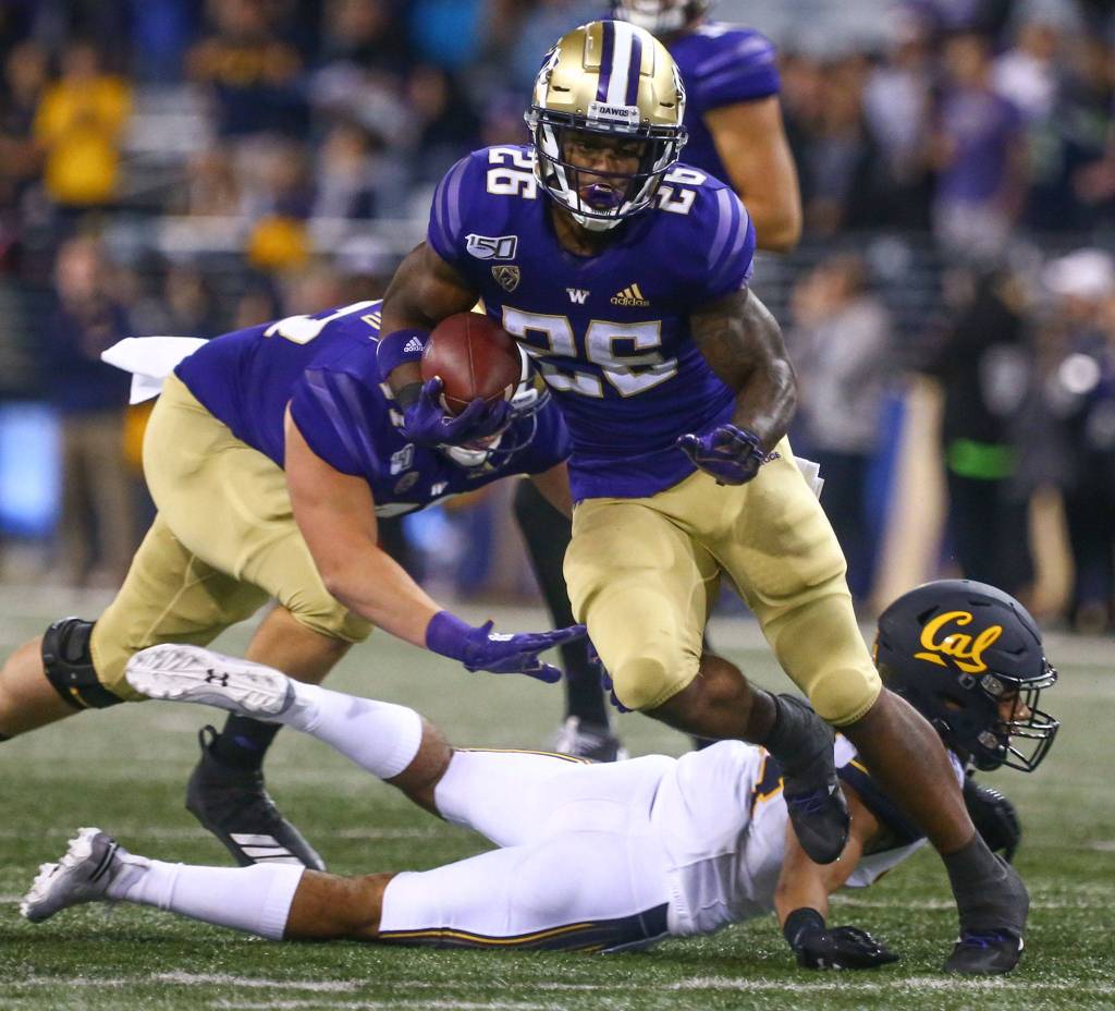 Washingtons Salvon Ahmed rushes for yardage against California Saturday night at Husky Stadium in Seattle on September 7, 2019.(Kevin Clark / The Herald)