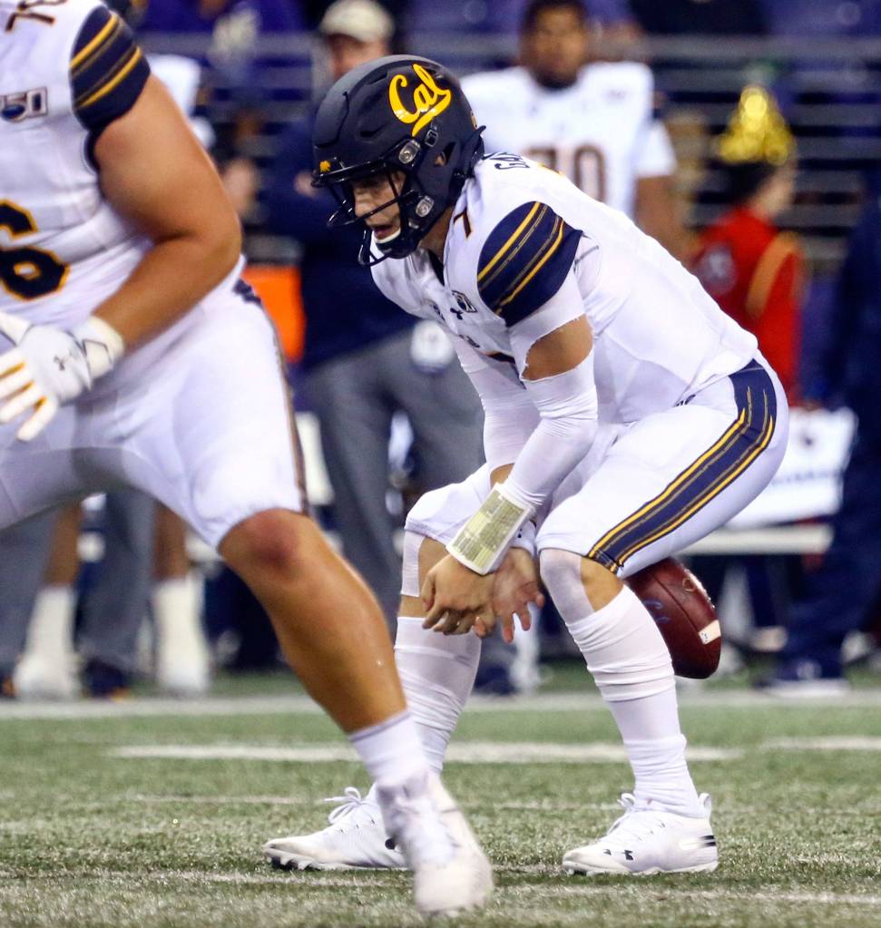 Californias Chase Garbers fumbles the snap Saturday night at Husky Stadium in Seattle on September 7, 2019.(Kevin Clark / The Herald)
