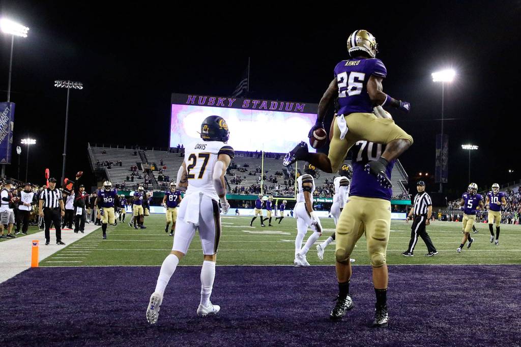 Washingtons Salvon Ahmed is lifted by Jared Hilbers in celebration after his touchdown against California Saturday night at Husky Stadium in Seattle on September 7, 2019.(Kevin Clark / The Herald)