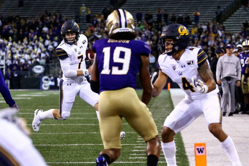 Californias Chase Garbers (left) eyes the goal line before going out of bound Saturday night at Husky Stadium in Seattle on September 7, 2019.(Kevin Clark / The Herald)