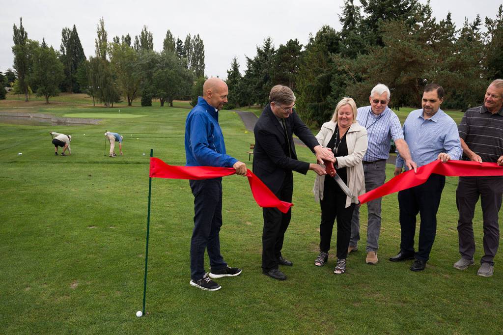 A ribbon is cut to comemorate a renovation project at Everetts Legion Memorial Golf Course on Wednesday. (Andy Bronson / The Herald)