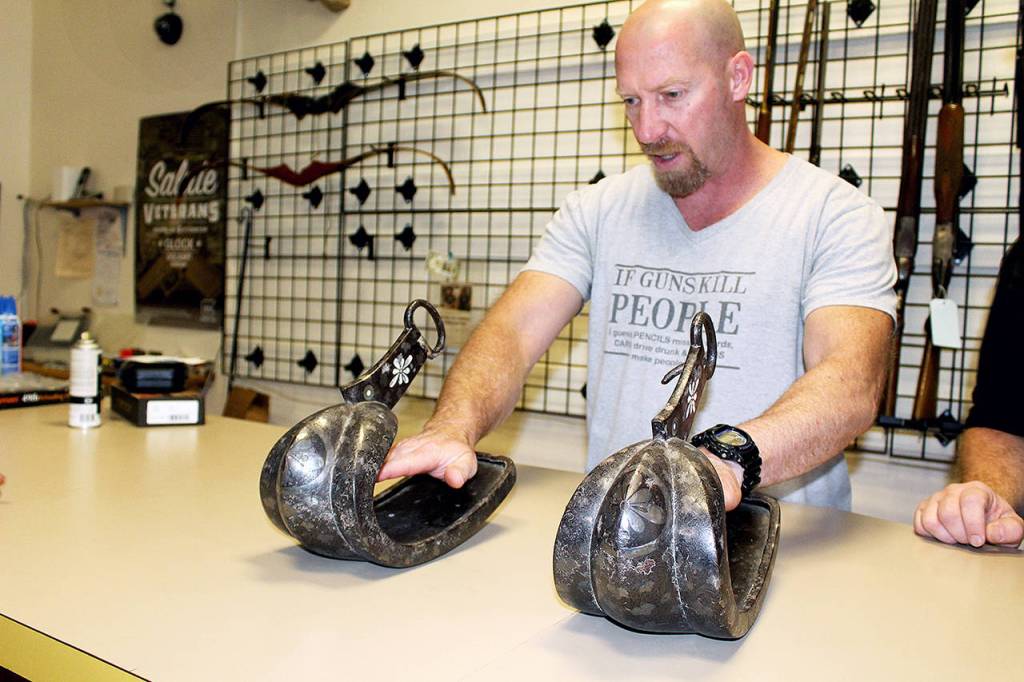 Military veteran Sherman Smitty Smith examines Japanese samurai warrior stirrups dating back centuries. (Wendy Leigh / South Whidbey Record)