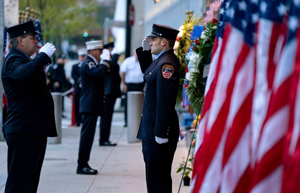 New York City firefighters salute in front of a memorial on the side of a firehouse adjacent to One World Trade Center and the 9/11 Memorial site during ceremonies on the 18th anniversary of 9/11 terrorist attacks in New York on Wednesday. (AP Photo/Craig Ruttle)