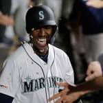 Sunflower seeds fly in the dugout as the Mariners Kyle Lewis is greeted after he hit a solo home run against the Reds during the fifth inning of a game Sept. 12, 2019, in Seattle. (AP Photo/Ted S. Warren)