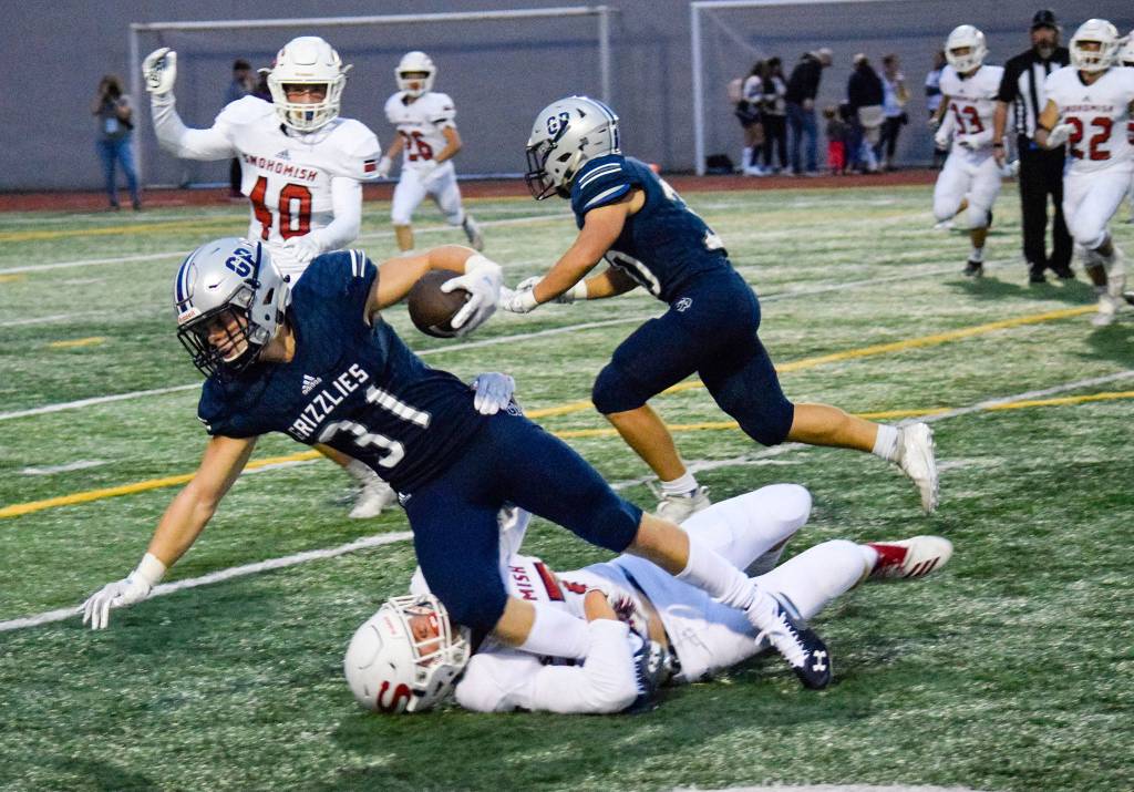 Junior wide receiver Patrick McKenzie falls while being tackled by a Snohomish defender on Friday, Sept. 13 at Veterans Memorial Stadium. (Katie Webber / The Herald)