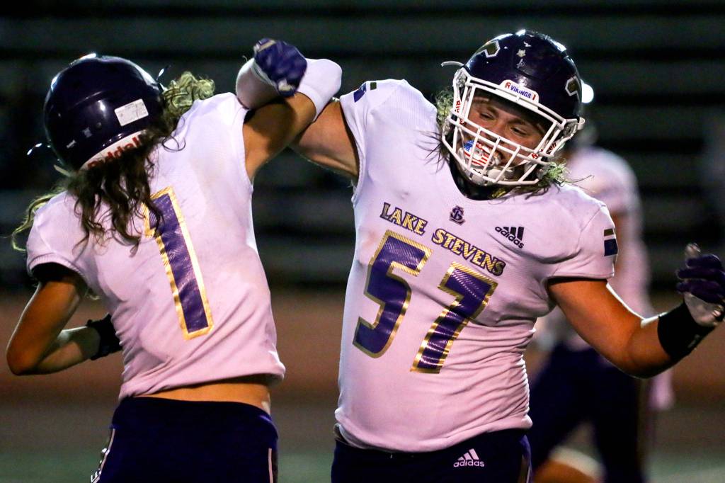 Lake Stevens Gabe Ramsey (left) and Austyn Rembold-Hyde celebrate Friday night at Lincoln Bowl in Tacoma on September 13, 2019. Lake Stevens won 35-26. (Kevin Clark / The Herald)