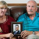 In this Sept. 9 photo, Rod and Tonya Meldrum hold a portrait of their son Devin Meldrum, in Provo, Utah. He suffered from debilitating cluster headaches and fatally overdosed after taking a single fentanyl-laced counterfeit oxycodone pill purchased from a dark-web store run by Aaron Shamo, according to his family and authorities. (AP Photo/Rick Bowmer)