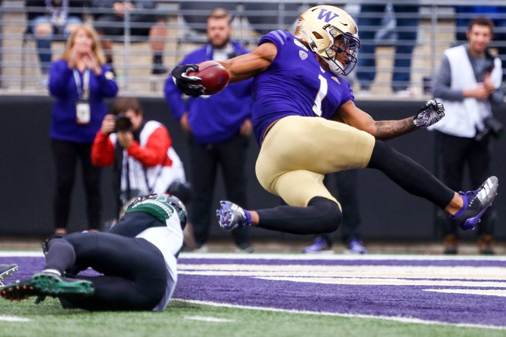Washingtons Hunter Bryant bounces into the end zone and a touchdown off Hawaiis Cortez Davis Saturday evening at Husky Stadium in Seattle on September 14, 2019. Husky won 52-20. (Kevin Clark / The Herald)