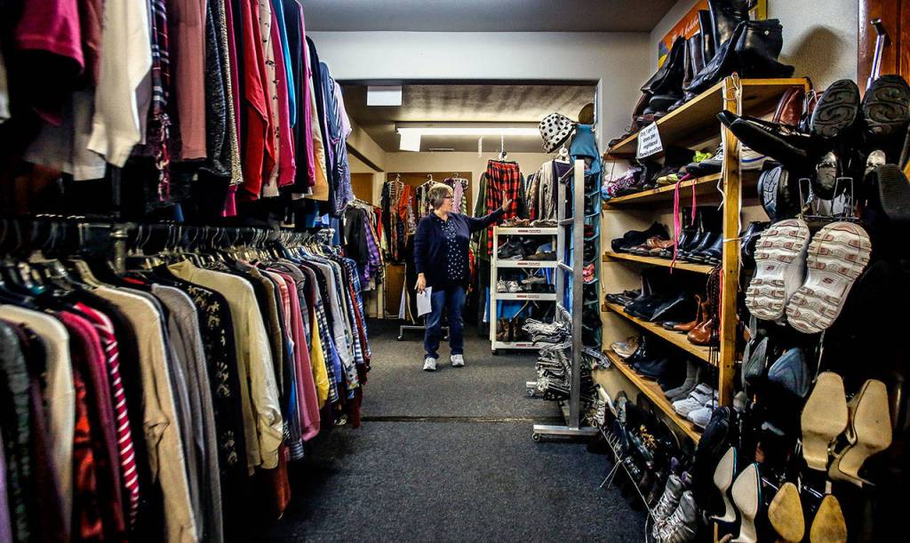 Saint Josephs House board member Sara Roach shows clothing available in the womens clothing area. The Marysville nonprofit will be helped by a benefit auction Oct. 19. (Dan Bates / The Herald)